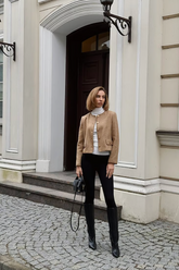 a lady in a white slim sweater, a brown jacket and a pair of black pants
